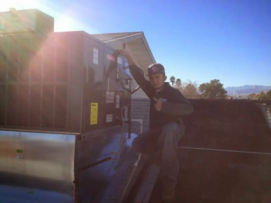 HVAC technician performing Air Duct Cleaning on a rooftop unit in German Flatts